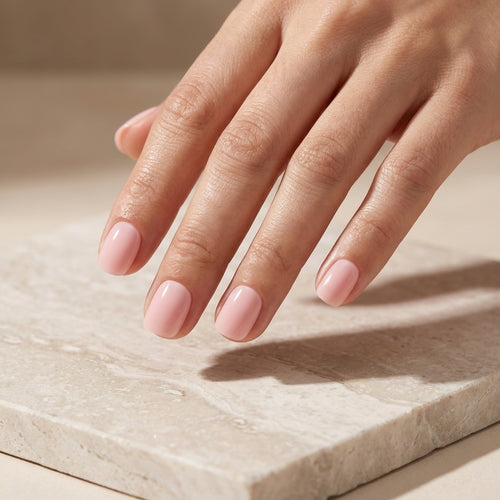 Pale Blush short oval Hushed reusable soft-gel press-on nails on hand.