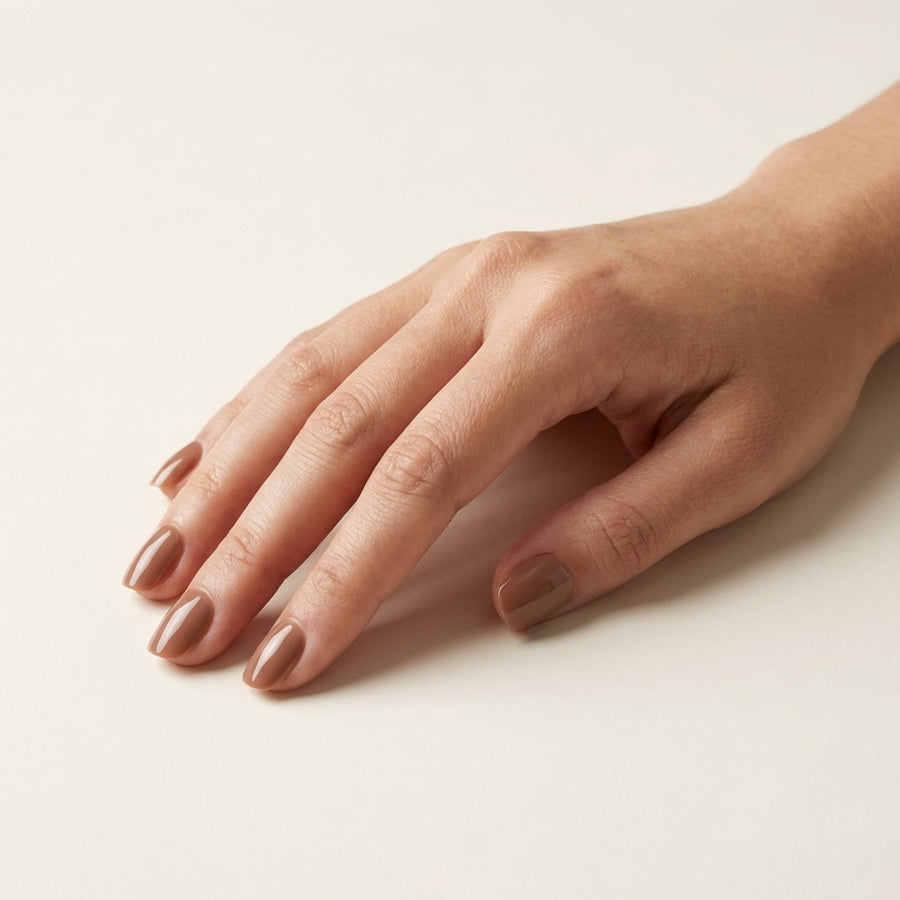 Soft Mocha short oval Hushed reusable soft-gel press-on nails on hand.